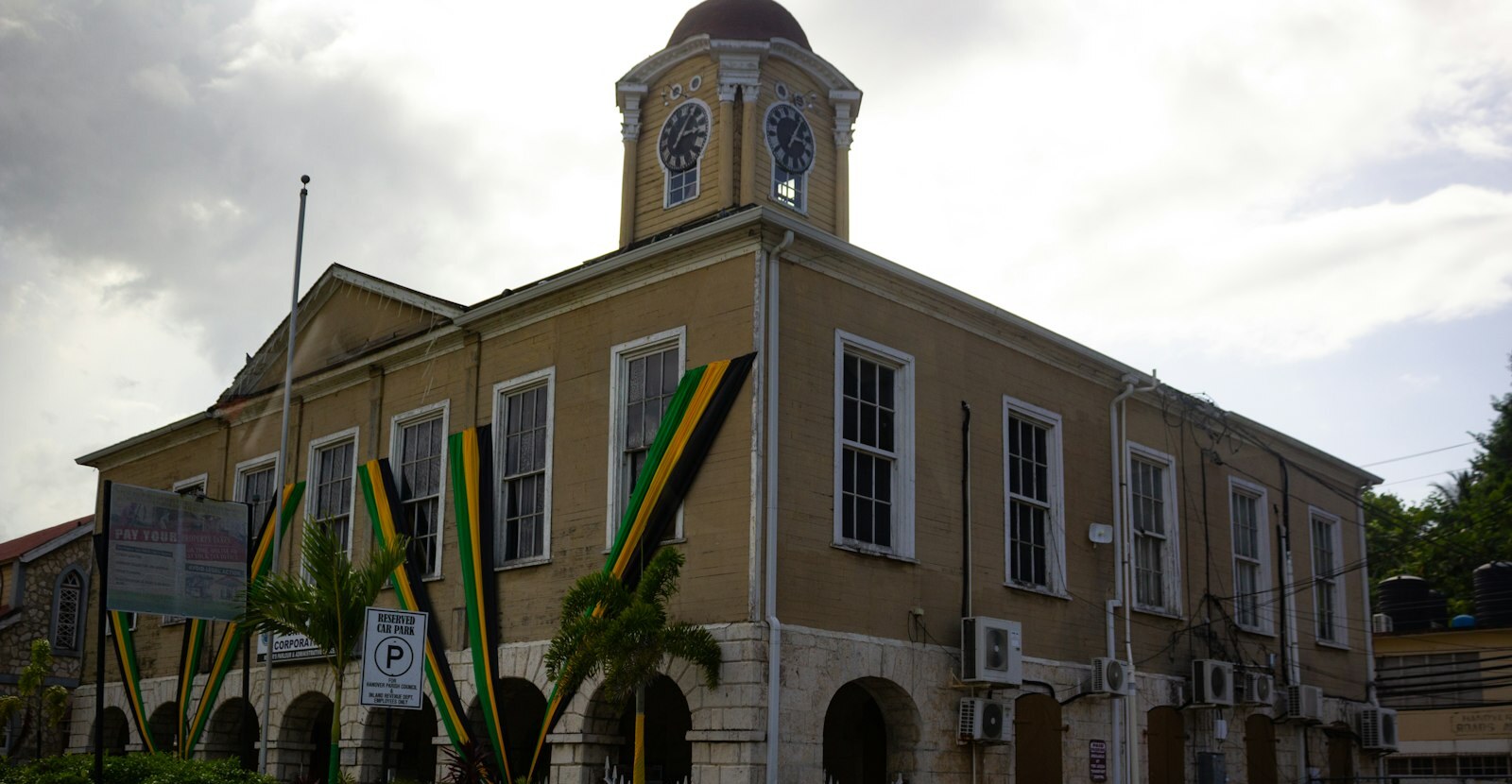 Hanover Parish Council building with a clock tower and Jamaican flag colours draped across its stone arches
